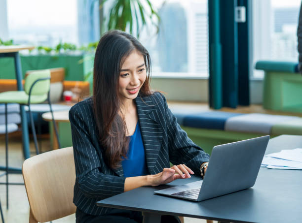istock Asian business woman in formalwear using laptop computer while working in small cafe for working from home and online education concept 1353006109