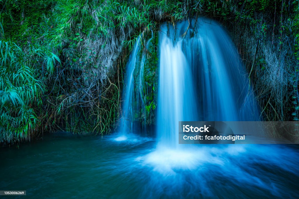 Small waterfall in forest. Blurred motion Long exposure shot of a small waterfall in wild nature. High resolution 42Mp outdoors digital capture taken with SONY A7rII and Zeiss Batis 25mm F2.0 lens Backgrounds Stock Photo