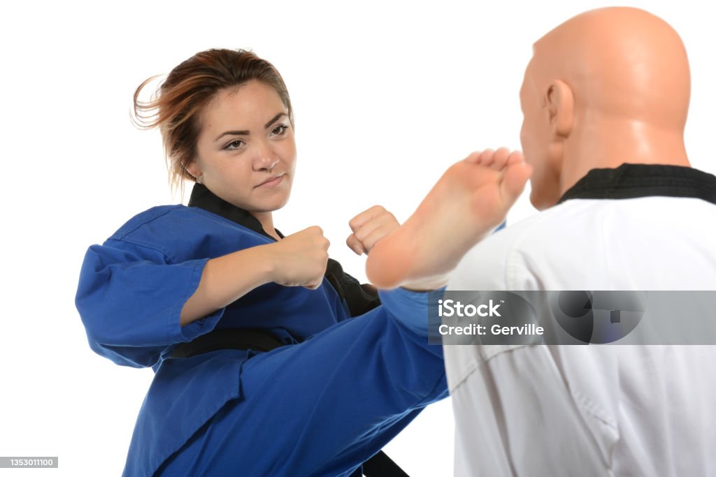 Tae Kwon Do Whip Martial artist kicking a training mannequin. Black Belt Stock Photo