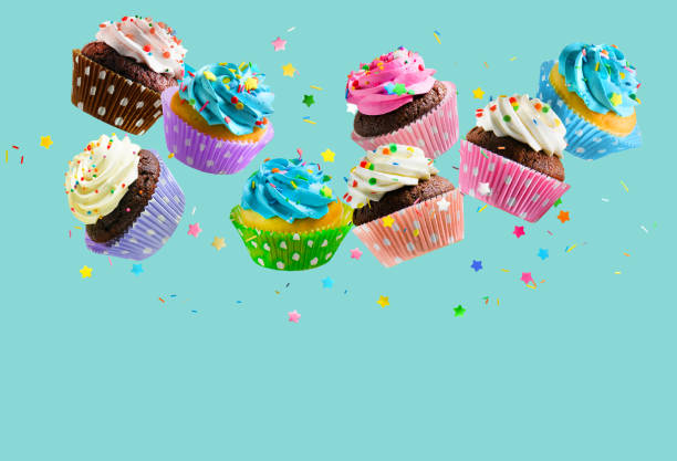 아쿠아 블루 배경 위에 떨어지는 다채로운 뿌려컵 케이크. 복사 공간 - cupcake 뉴스 사진 이미지