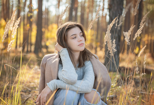 Portrait of a thoughtful and sad girl. Autumn colors . Lifestyle. Autumn mood. Forest