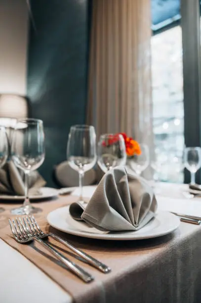 Photo of Elegant table set in modern style dining room interior