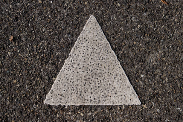 Close up of a isosceles triangel painted with thick white paint on the asphalt Close up of a isosceles triangel painted with thick white paint on the asphalt isosceles triangle stock pictures, royalty-free photos & images