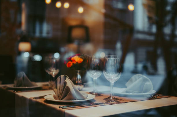 Luxury table setting  with a flower arrangement in a middle.Looking through window