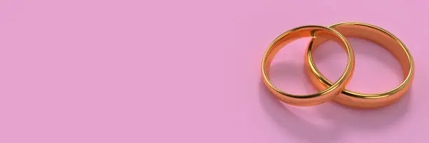 Banner of two wedding gold rings lie on each other with blank space background. 3d rendering