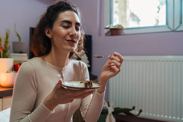 istock Charming young woman enjoying the piece od chocolate cake 1353026540