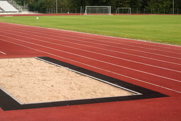 Athletic tracks and sand jump trap Athletic track red surface and sand trap for long Jump and triple Jump long jump stock pictures, royalty-free photos & images