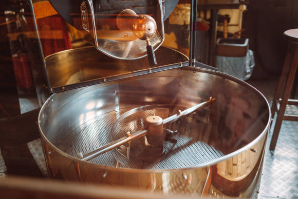 máquinas profesionales de enfriador tostado vacío para el movimiento de granos de café marrón frescos de cerca en la fábrica - roasted machine bean mixing fotografías e imágenes de stock