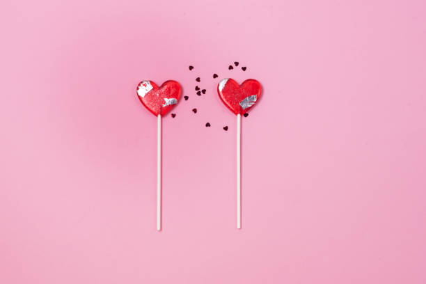 istock Two Lollipops Hearts Red Confetti Candy Love Concept Valentine Day Horizontal 1353038996