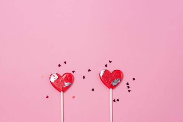 istock Two Lollipops Hearts Red Confetti Candy Love Concept Valentine Day Copy Space 1353039531