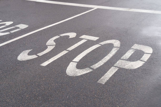 istock Road markings on the asphalt - line and text Stop 1353040435