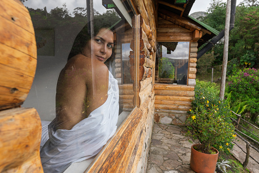 Portrait of a young latin woman from bogota Colombia between 30 and 34 years old, looking out the cabin window enjoying the scenery on her vacation