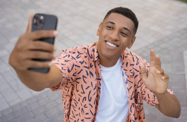 istock Smiling American man using mobile phone communication online. Happy tourist taking selfie on the street 1353041536