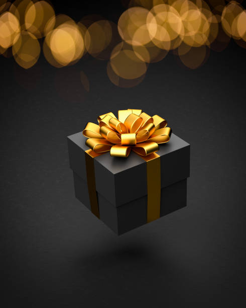 istock A dark present box with golden ribbon and bow hovering over a black stone background. Bokeh lights in the background 1353046487