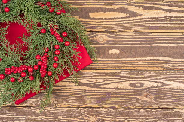 istock Christmas wreath with red winter berries on a wooden table 1353055872