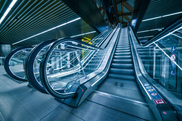 viajeros en escalera mecánica en la estación de metro canary wharf - stair rail fotografías e imágenes de stock