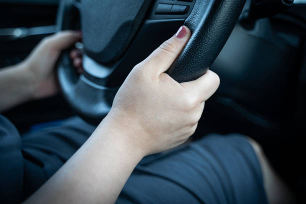 istock Young woman holding steering wheel with hands while driving a car 1353062572