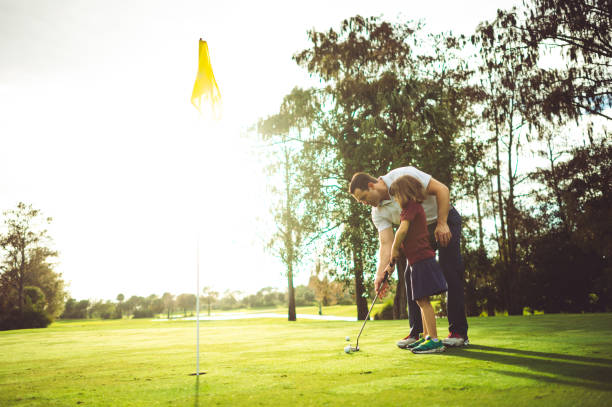 istock Man instructs girl on golf course, father or coach 1353062691