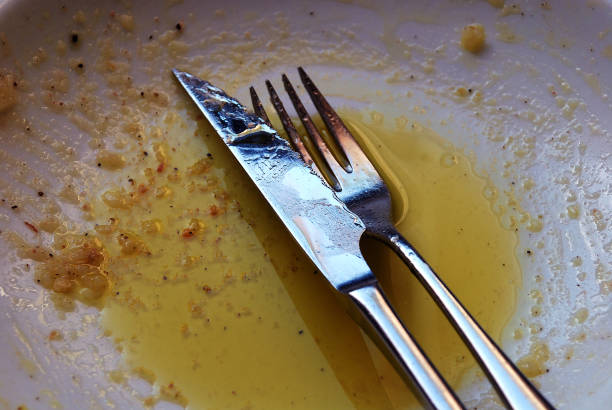 istock Knife and fork on a finished food plate 1353062700