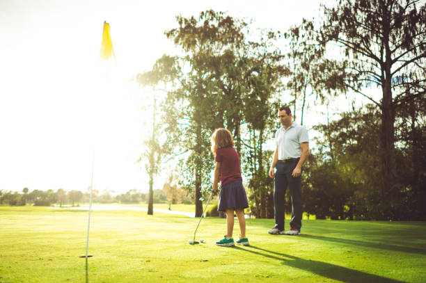 istock Man instructs girl on golf course, father or coach 1353062729