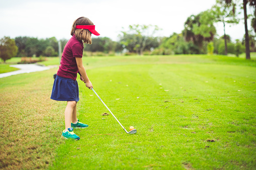 Young girl golfs on a golf course in West Palm Beach Florida