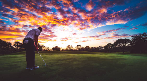 hombre en un idílico campo de golf escénico poniendo al atardecer, belleza en la naturaleza - putting golf golfer golf swing fotografías e imágenes de stock
