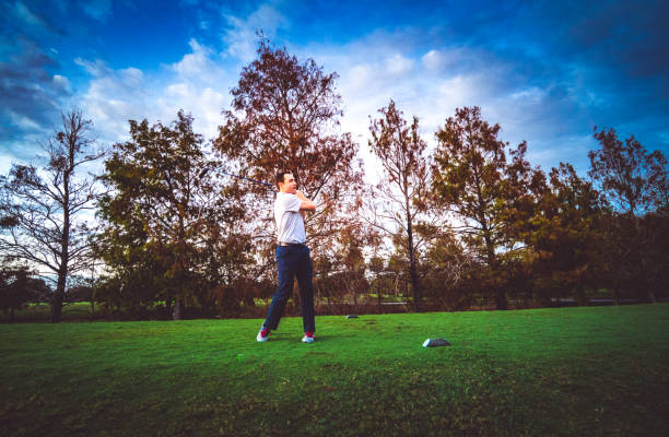 istock Man on a scenic golf course swings a golf club 1353064804