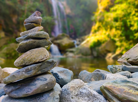 Stone Stacking or Stone Balancing, Stone pyramid near a tropical waterfall.The concept of harmony and balance.