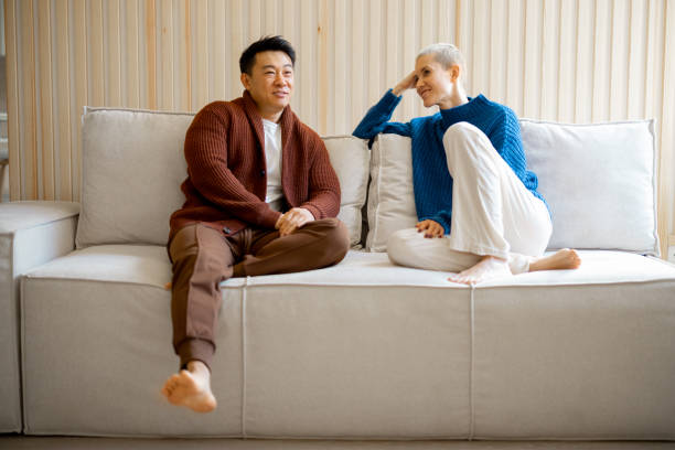 istock Multiracial couple sit and talk on sofa at home 1353065377