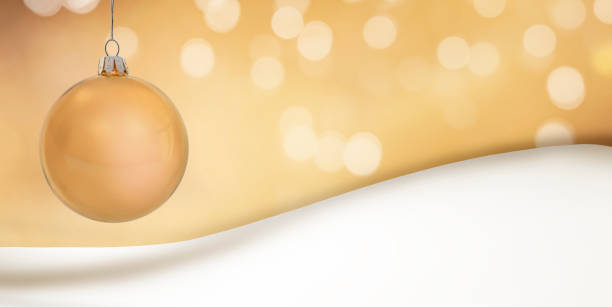 Golden Christmas ball against a blurred background and snowdrift