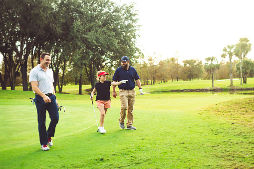 Two fathers and a girl play golf together in West Palm Beach Florida, Okeeheelee golf course