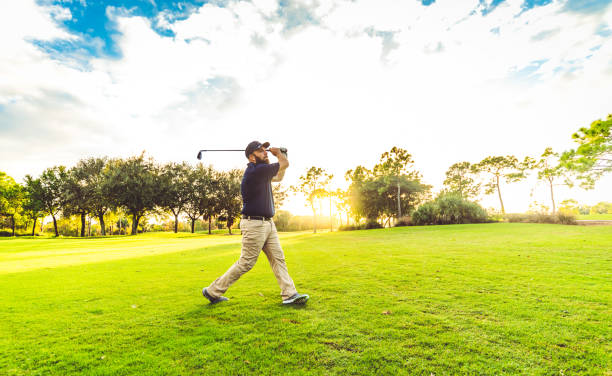 istock Man on a scenic tropical golf course teeing off taking a swing 1353067763