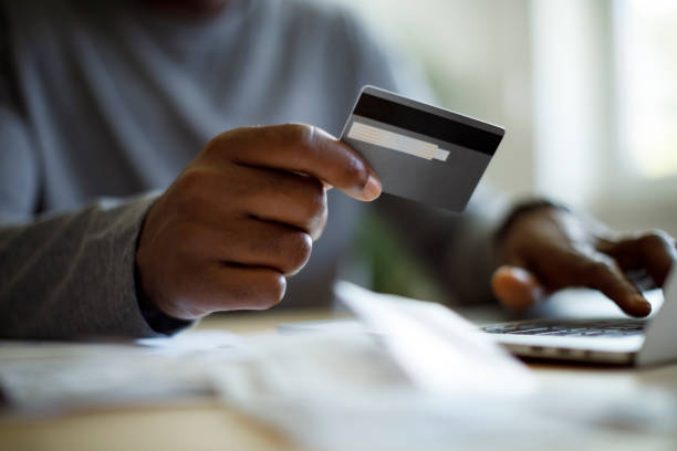 mann mit kreditkarte rechnungen bezahlen - gebühr stock-fotos und bilder