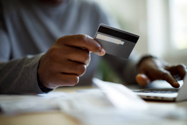 Man using a credit card to pay bills Man using a credit card to pay bills white collar crime stock pictures, royalty-free photos & images