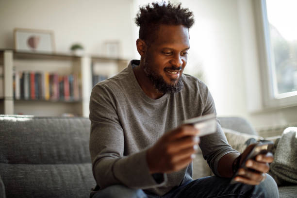 istock Young smiling man shopping online with credit card 1353068036
