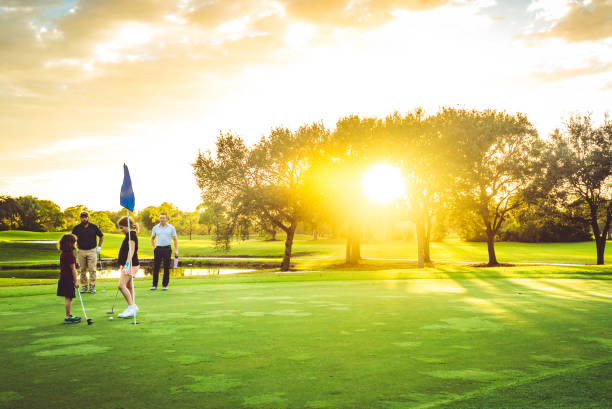 istock Family with two fathers and two daughters play golf together on scenic golf course, active sporty family bonding 1353069380