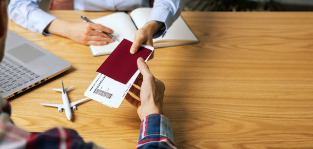 customer buying flight tickets in travel agency for his next trip stock photo