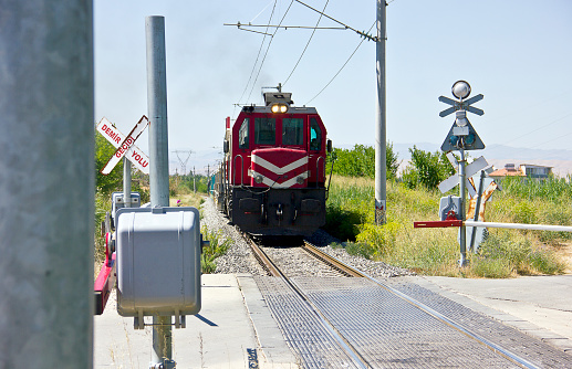 railway crossing stop sign with empty rail tracks on the background in malatya dilek turkey. There is writing stop sign in turkish \