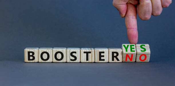 Covid-19 booster vaccine shot yes or no symbol. Doctor turns wooden cubes and changes words booster no to booster yes. Beautiful grey background, copy space. Covid-19 booster vaccine shot concept. stock photo