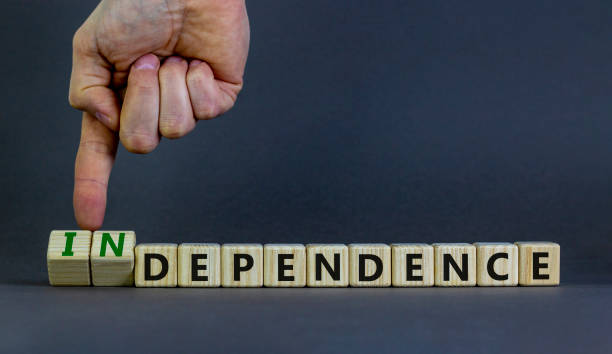 istock Dependence or independence symbol. Businessman turns cubes and changes the word 'dependence' to 'independence'. Beautiful grey background, copy space. Business, dependence or independence concept. 1353074216