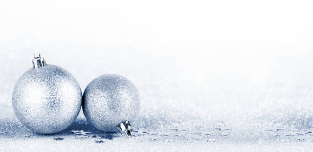 istock Christmas boubles on silver glitter with sparkling defocused lights on background. Blue tone 1353075510