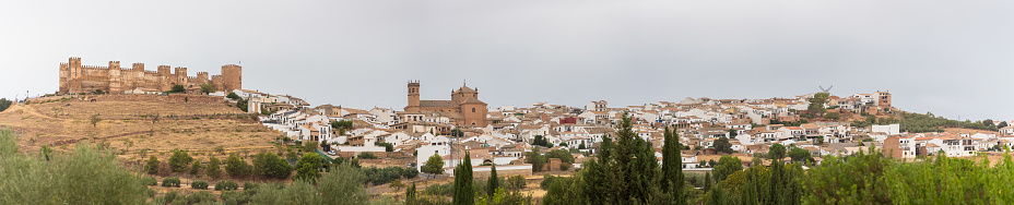 Baños de la Encina Jaén Spain - 09 12 2021: Amazing ultra panoramic view at the Baños de la Encina village, medieval Castle and San Mateo church