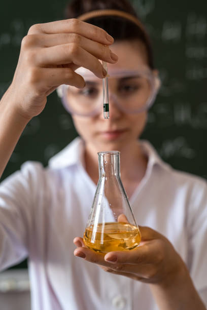 kobieta naukowiec wykonująca badania naukowe z kolbą chemiczną i cieczą w szkolnym laboratorium - test tube glass reagent red zdjęcia i obrazy z banku zdjęć