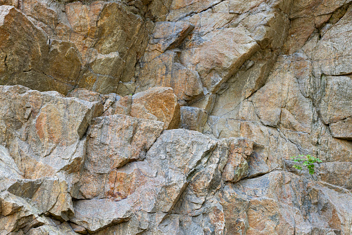 Cracks in the granite rock due to human activity. Destruction of the granite rock of the mountain after the explosion. Concept of environmental problems