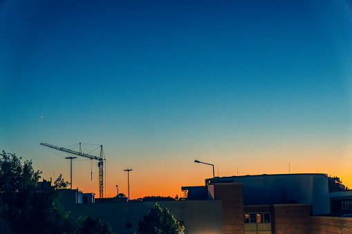View of a city in setting sun with a construction site.