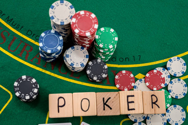 wooden dice on which writes poker playing cards and chips laid out on a poker table. Poker concept