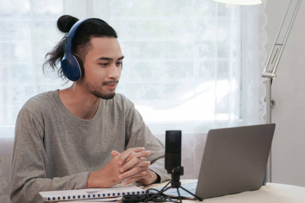 istock Asian Man Work from Home. young man is using laptop for conference call meeting. communication technology business online platform. Concept business Switching to Remote Work. 1353082661
