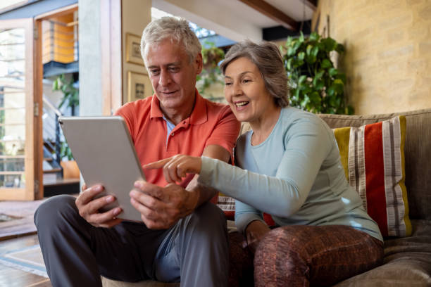 istock Senior couple at home talking on a video call using their tablet 1353083027
