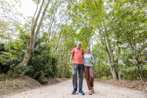 istock Happy senior couple having fun walking in the forest 1353083031