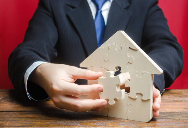istock Puzzle house with a missing piece. Purchase or construction comfortable dream home. Mortgage loan purchase real estate. Arrangement premises repair. Availability and cheapness. Finish building 1353083846